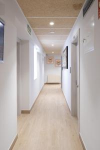 an empty hallway with white walls and wood floors at Hotel La Cortijana in Logroño