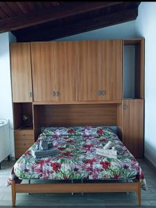 a bedroom with a bed with wooden cabinets at Dimora al parco in Domusnovas