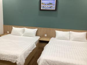 two beds sitting next to each other in a room at Hotel88 in Ấp Bình Hưng