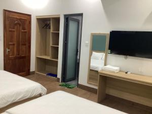 a bedroom with a tv and a bed and a mirror at Hotel88 in Ấp Bình Hưng
