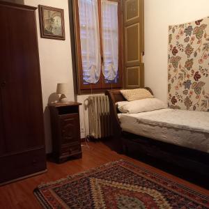 a bedroom with a bed and a rug and a window at ANTICA CASA AL LAGO in Oggebbio