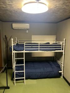 two bunk beds in a room with a ceiling at 民泊寿屋Kotobukiya Guesthouse in Muroran +11 photos