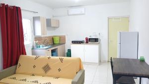 eine Küche mit Sofa, Tisch und Kühlschrank in der Unterkunft résidence IDIMAH in Sada