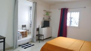 ein Schlafzimmer mit Bett, Schreibtisch und Fenster in der Unterkunft résidence IDIMAH in Sada