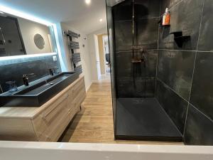 a bathroom with a black shower and a sink at CALME - 15 min Toulouse - PISCINE - SPA in Mons +10 photos