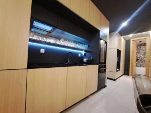 a kitchen with black walls and wooden cabinets and a sink at 74SUITE Sibenik - Self check in - Garage in Šibenik