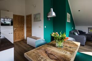 a living room with a table with a vase of flowers on it at Zeebungalows Terschelling in Formerum