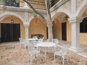 a patio with tables and chairs in a building at Casa Lucia Valladolid in Valladolid