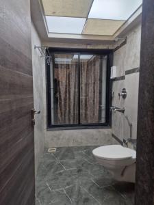 a bathroom with a toilet and a window at Tejas inn in Pune