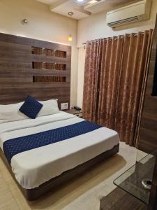 a bedroom with a large bed with a wooden headboard at Tejas inn in Pune