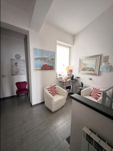 a living room with two chairs and a table at Blue Sky House in Taormina