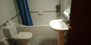 a bathroom with a toilet and a sink and a tub at Beachside Vacation House in Ras al Khaimah +1 photo