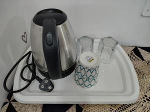 a mixer on a counter with two glasses on it at The Rest Nest in Gorakhpur