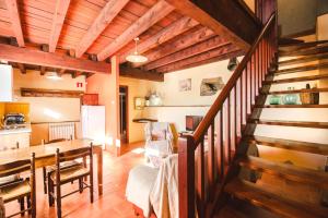 a living room with a wooden staircase and a kitchen at Can Bonada in El Serrat