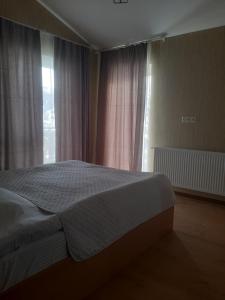 a bedroom with a bed and a large window at Maia's Cottage in Bakuriani