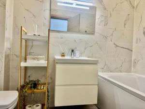 a white bathroom with a sink and a bath tub at Sasha Collection by AlezziNord10 in Constanţa +10 photos
