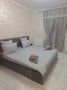 a bedroom with a large bed with towels on it at Apartment Zona 0 Tulcea in Tulcea