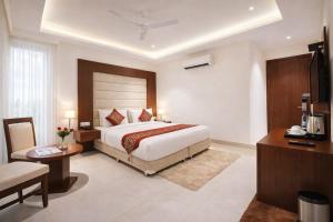 a hotel room with a bed and a desk and a desk at Yashobhoomi Hotel Z Suites- FREE Airport Pickup & Drop in New Delhi