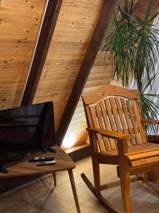 a wooden chair and a television in a room at Agora Farmhouse in Koman