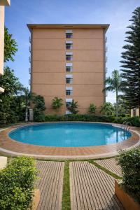 a swimming pool in front of a building at Puerto Princesa Studio Condo with 2 Large Beds, Balcony, Pool & Gym in Puerto Princesa City