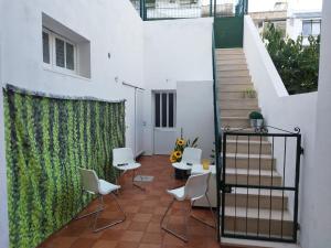 a balcony with white chairs and a stair case at Chill Spot - Faro Hostel in Faro