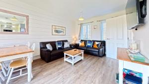 a living room with two couches and a table at Nantucket Cottage - Part of the The Bay Filey Holiday Village with pool, gym and direct beach access, pub, restaurant, tennis and meadows walks in Filey