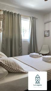 a bedroom with a large bed with a window at La Laguna Cruz del Eje in Cruz del Eje