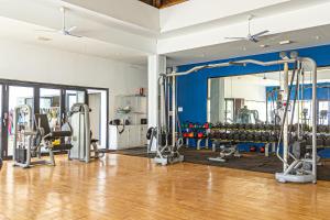 a gym with a large mirror and lots of equipment at TUI BLUE Tamala in Kotu
