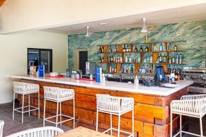 a restaurant with a bar with white chairs at TUI BLUE Tamala in Kotu