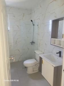 a white bathroom with a toilet and a sink at bienvenido a casa in San Pedro de Macorís +4 photos