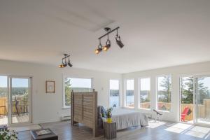 a white bedroom with a bed and windows at Whale House Guest House in Mobile