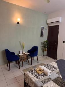a bedroom with blue chairs and a bed and a table at Rosewood Cottage in Karachi +62 photos