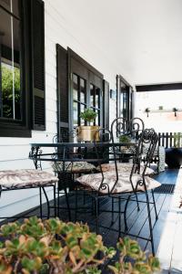 a patio with chairs and tables on a house at Ebony & Ivory Villa in Nelson Bay