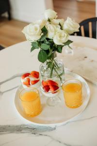 a plate with a vase with flowers and fruit at Ebony & Ivory Villa in Nelson Bay