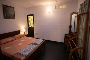 a small bedroom with a bed and a chair at Ora Living in Maskeliya