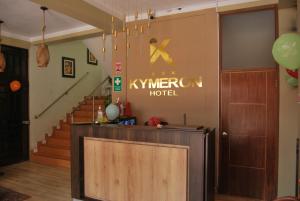 a hotel lobby with stairs and a sign on the wall at Kymeron Hotel in Juliaca