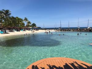 a group of people in the water at a beach at La bellevue in Les Trois-Îlets