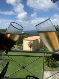 two glasses of wine in front of a balcony at La bellevue in Les Trois-Îlets