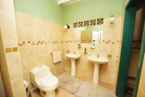 a bathroom with a toilet and two sinks at finca la sultana in Salento