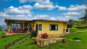 a yellow house with a hammock in front of it at finca la sultana in Salento