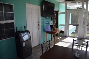 a living room with a television and a table and chairs at Bamboleo Inn in Ladyville
