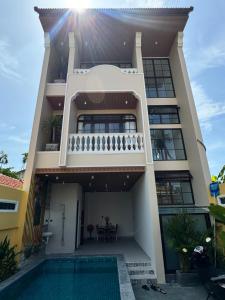 a house with a swimming pool in front of it at Mom Villa - Cẩm Thanh in Hiếu Nhơn