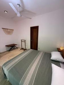 a bedroom with a bed and a ceiling fan at la baxada mazunte in Mazunte