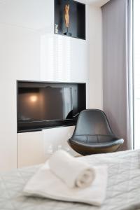 ein schwarzer Sessel in einem Schlafzimmer mit einem Fernseher in der Unterkunft Unique Integrated Hotel in Zadar