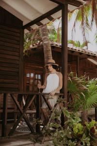 a woman in a hat is standing on a porch at Petit Lafitte Beach Front Hotel & Bungalows in Playa del Carmen +47 photos
