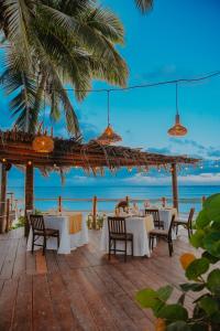 a restaurant on the beach with tables and chairs at Petit Lafitte Beach Front Hotel & Bungalows in Playa del Carmen