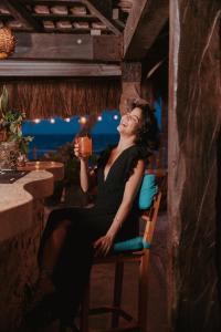 a woman sitting in a chair holding a drink at Petit Lafitte Beach Front Hotel & Bungalows in Playa del Carmen