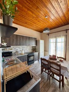 a kitchen with wooden ceilings and a table with chairs at Patrikon in Zagora