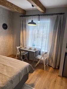 a bedroom with a table and chairs and a window at A33 central studio aparthotel in Liepāja
