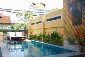 a swimming pool in front of a house at Mom Villa - Cẩm Thanh in Hiếu Nhơn